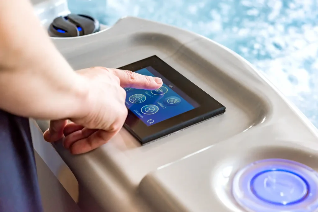 Hand bedient Touchdisplay zur Steuerung eines Whirlpools mit digitalem Bedienfeld und blauer Beleuchtung.