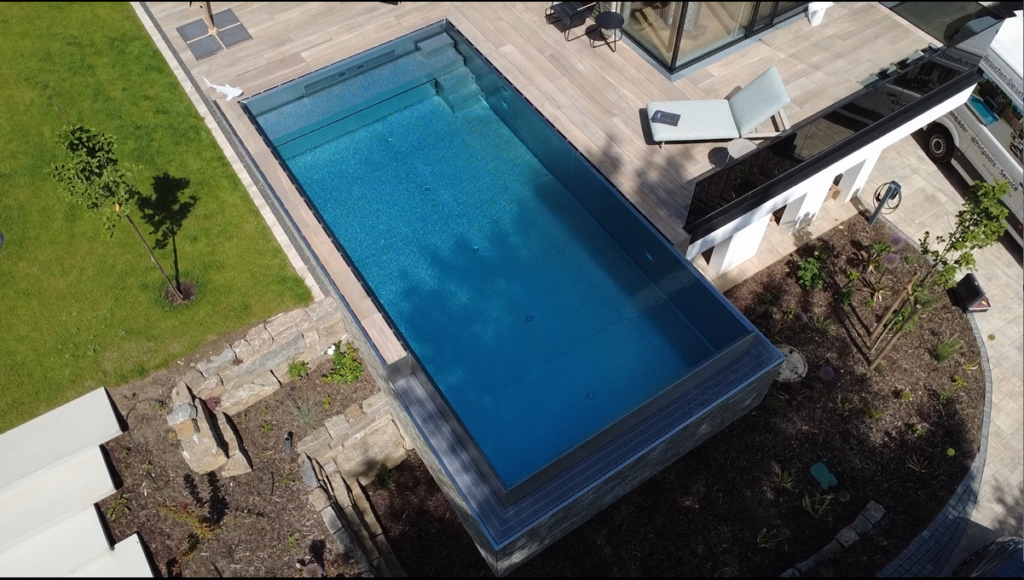 Luxuriöser Edelstahlpool mit Infinity-Überlauf und tiefer Überlaufrinne. Klare Linien, modernes Design und ein beeindruckend ruhiger Wasserspiegel schaffen ein einzigartiges Ambiente.
